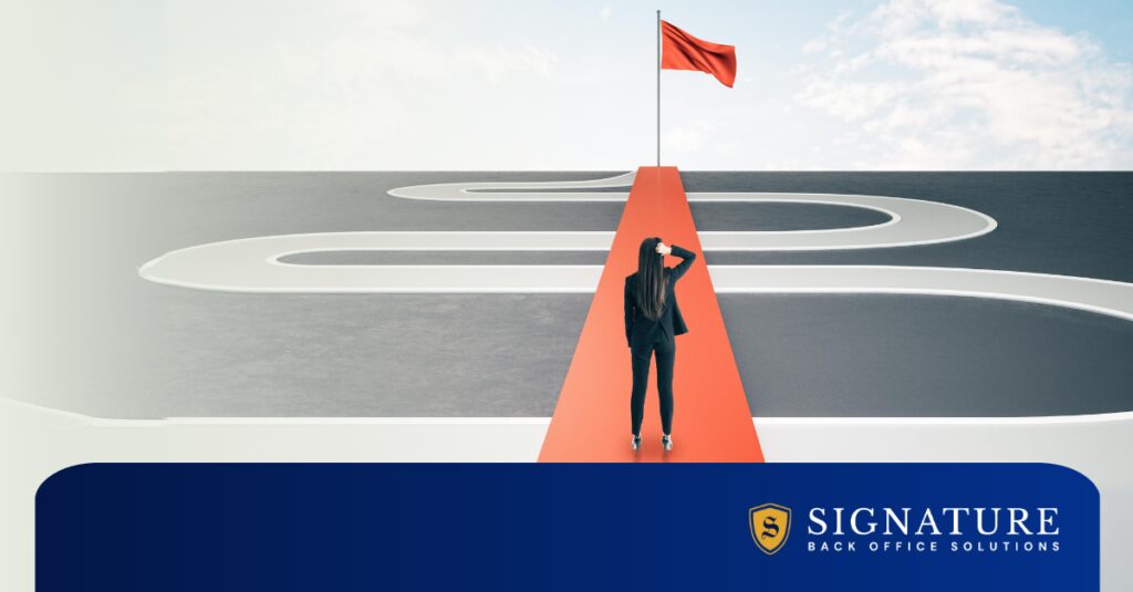Woman in business attire standing at one end of a red bridge leading to a red flag, overlaying a winding monochromatic road
