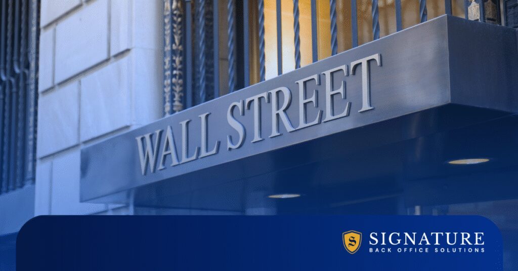 A metal sign reading "WALL STREET" is mounted on a building with bars on the windows.
