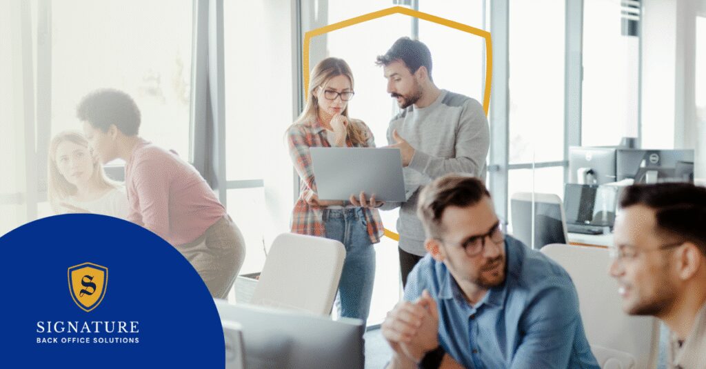 Professionals in a modern office discuss outsourcing payroll for staffing firms, highlighting its benefits in reducing administrative work and improving efficiency.