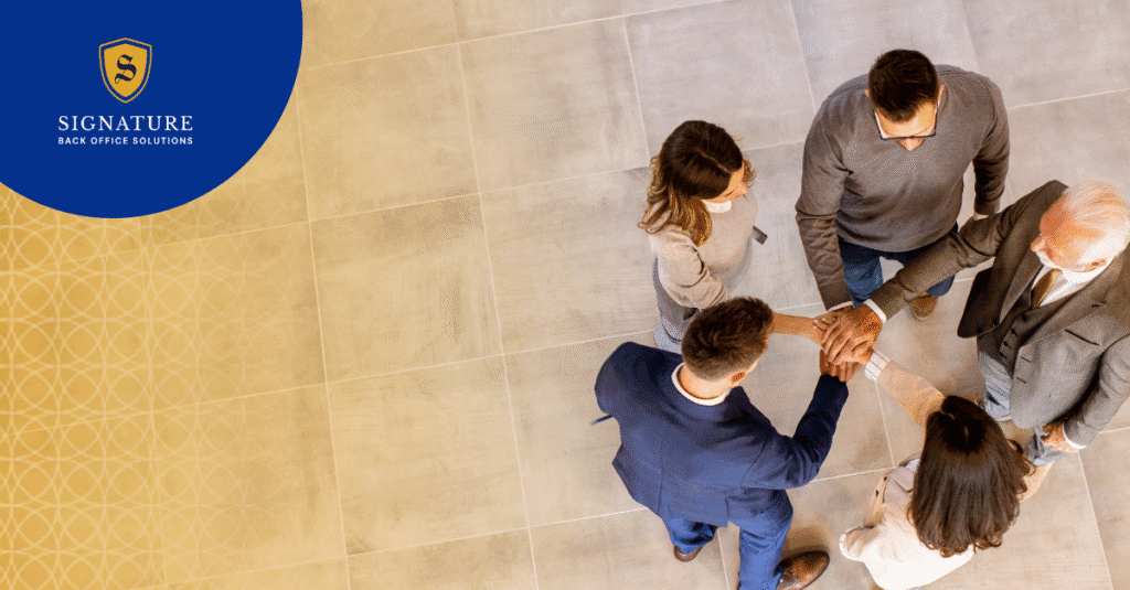 Business professionals shaking hands in team meeting discussing contingent workforce compliance solutions