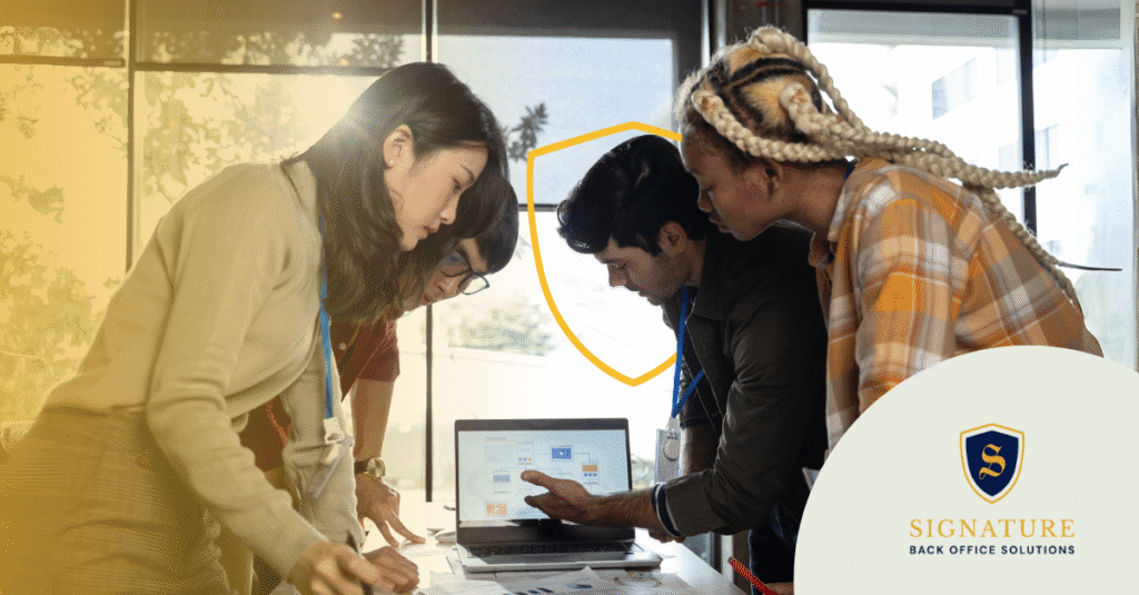 Diverse team collaborating around laptop discussing contract staffing business model strategies.