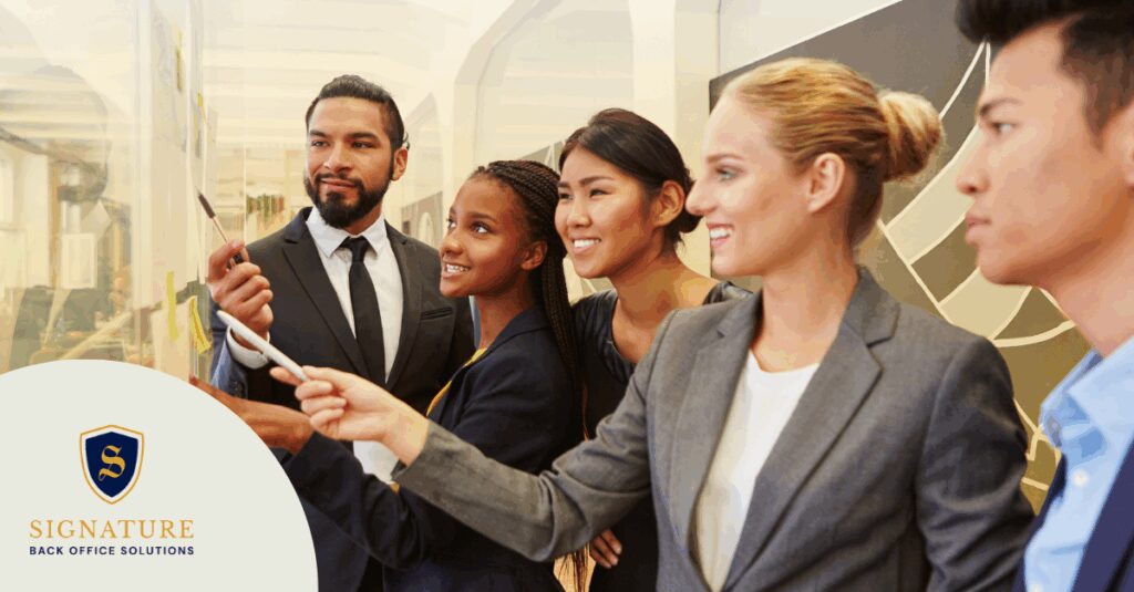 Five staffing professionals examining growth chart together to choose back-office partner before expansion.