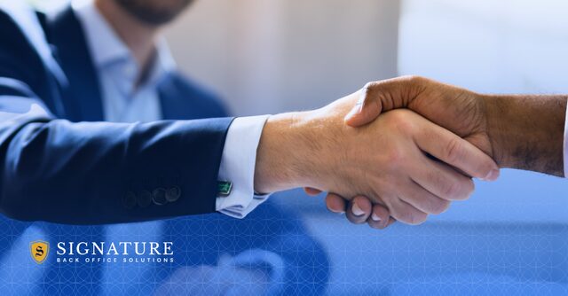 Business professionals shaking hands during year-end risk assessment planning to protect staffing firm profits before the new year begins.