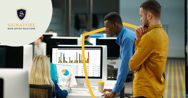 Office team conducting staffing firm data analysis on computer with charts and metrics displayed.