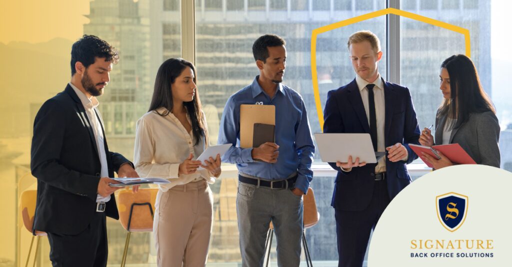 Business professionals reviewing staffing compliance workers comp regulations during team meeting.