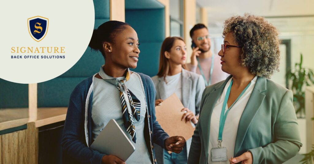 Diverse workplace professionals networking in an office hallway to reduce contractor turnover staffing.