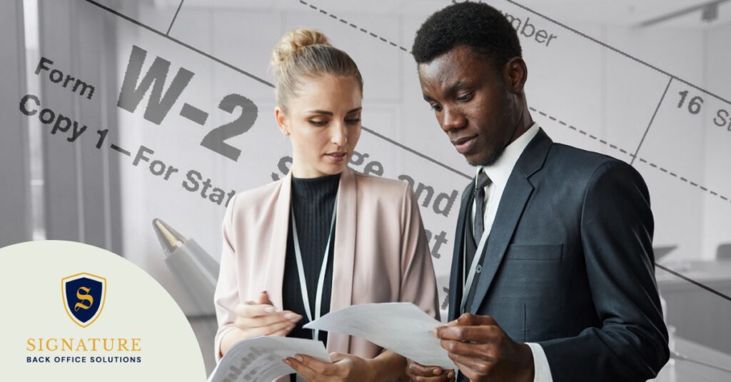 Two staffing professionals reviewing W-2 compliance documents in a professional office setting.