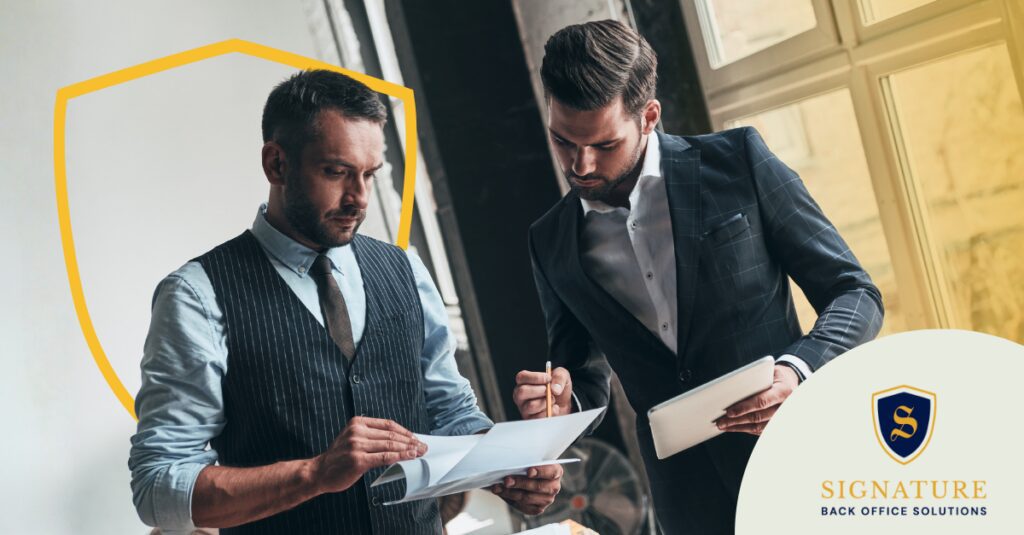 Two business leaders reviewing documents together as part of a staffing firm valuation for hybrid models.